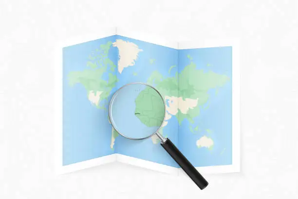 Vector illustration of Enlarge Gambia with a magnifying glass on a folded map of the world.