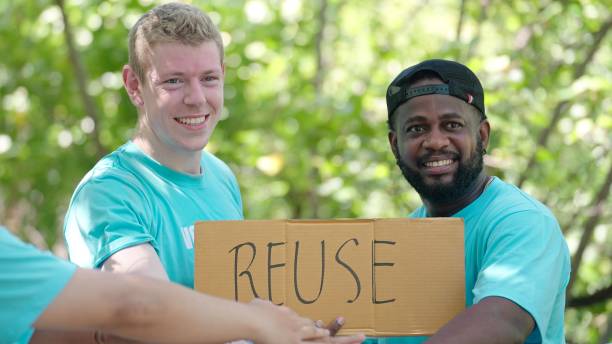 istock Volunteer to help save nature, pick up trash, hold a re-use sign activists starting work with cheering and stacking hands in the circle 1468532036