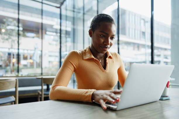 istock Young african woman freelancer working on laptop while sitting in coworking 1468534741