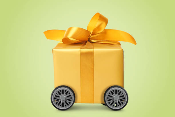istock Gift box on wheels against yellowish green background. Delivery service 1468536200