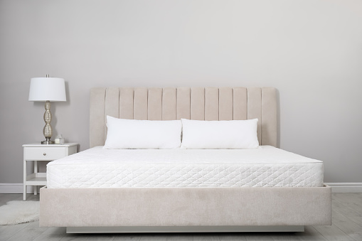 Cómoda cama con colchón blanco suave y almohadas en el interior photo