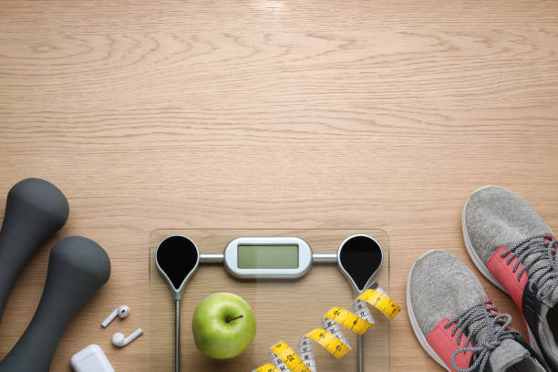 istock Flat lay composition with electronic scales and measuring tape on wooden background, space for text 1468542386