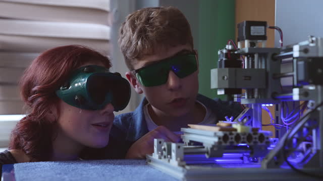 High school students watching at laser engraving