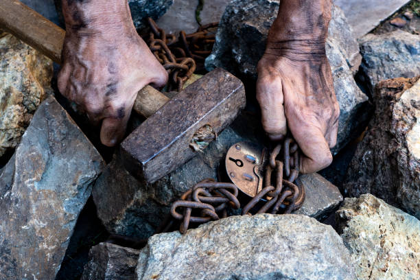 as mãos de um escravo na tentativa de libertação. o símbolo do trabalho escravo. mãos acorrentadas - throwing stone human hand rock - fotografias e filmes do acervo