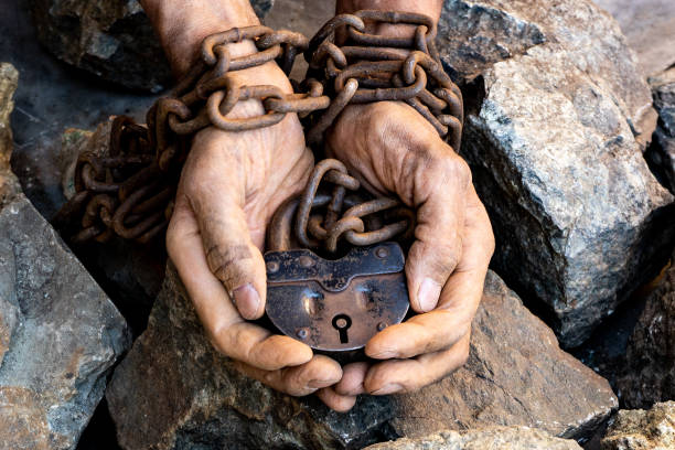 as mãos de um escravo na tentativa de se libertar. mãos acorrentadas - old prison punishment dirty - fotografias e filmes do acervo
