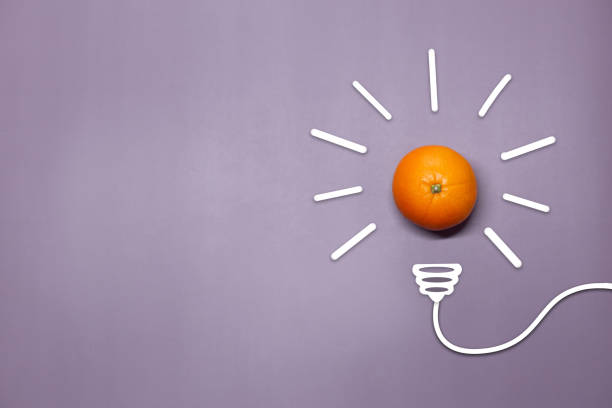 istock Creative thinking ideas and innovation concept. A ball of orange with a light bulb symbol on a lilac background. Time for a healthy diet. 1468550975