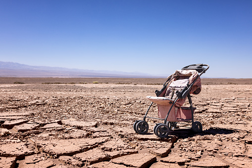 Apocalyptic scenery with an abondoned stroller on dry soil in the Atacama desert close to the oasis Pica.