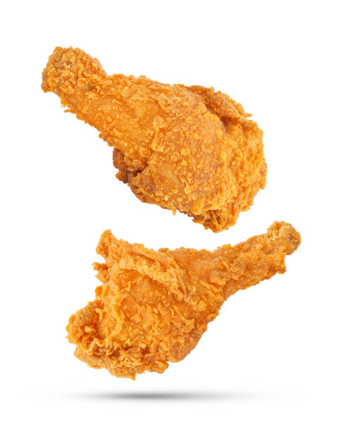 cosce di pollo fritte che cadono nell'aria isolate su bianco - pollo fritto foto e immagini stock