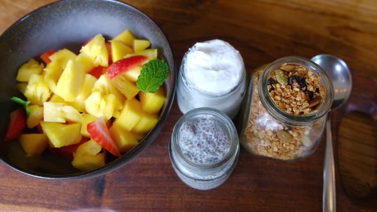 Smoothie with fruits, yogurt, granola, chia seeds in a glasses in cafe.