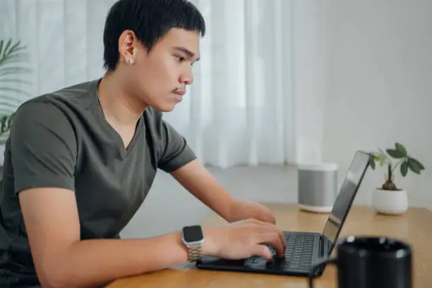 Photo of Handicapped man calculating personal expenses at home.