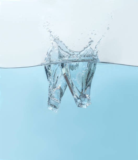 istock Ice cubes falling in blue clear water with splashes 1468562892