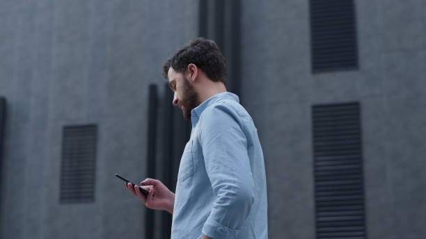 istock Focused ceo texting message phone at modern glass building. Businessman calling 1468563781