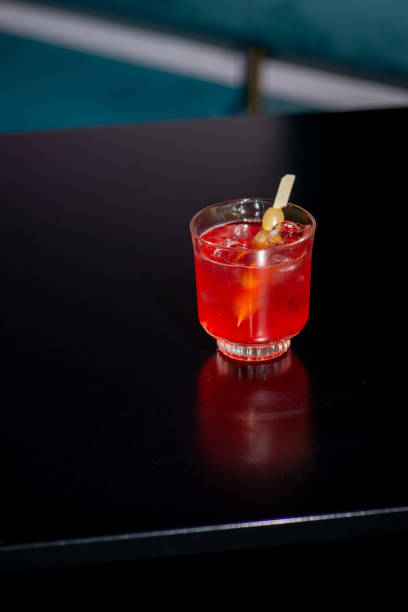 istock Cocktail red in hand on a dark background in the bar 1468564147