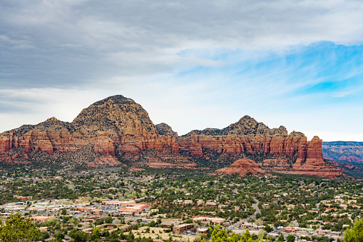 This is a high angle photograph of the scenic mountain landscape rising up above the town of Sedona, Arizona in spring time.