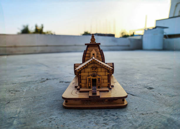 Stock photo of beautiful hand made wooden miniature of Kedarnath Temple kept on floor under natural light. Picture captured at Gulbarga, Karnataka, India. ancient temple dedicated to Lord Shiva. stock photo