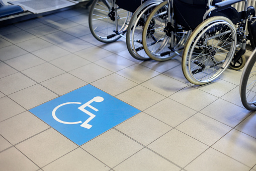 Group of wheelchairs in an airport departure area with no people.
