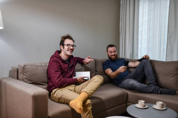 istock Gay Couple Enjoying Afternoon Spent Together Watching Sitcoms 1468568794