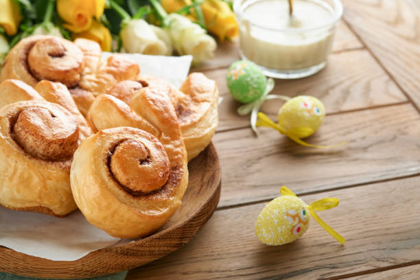 istock Easter breakfast Holliday concept. Easter bunny buns rolls with cinnamon made from yeast dough with orange glaze, easter decorations, colored eggs on old wooden background. Easter Holliday card. 1468568906