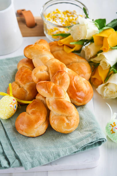 Easter breakfast Holliday concept. Easter bunny buns rolls with cinnamon made from yeast dough with orange glaze, easter decorations, colored eggs on white spring background. Easter Holliday card. desayuno de pascua concepto holliday. rollos de bollos de conejo de pascua con canela hechos de masa de levadura con glaseado naranja, decoraciones de pascua, huevos de colores sobre fondo blanco de primavera. tarjeta de vacaciones de pascua.