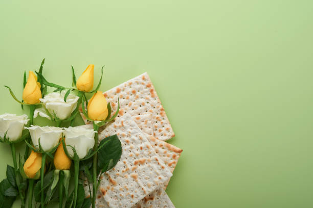 istock Passover celebration concept. Matzah, kosher red wine, walnut and spring white and yellow rose flowers. Traditional ritual Jewish bread on light green background. Passover food. Pesach Jewish holiday. 1468570227