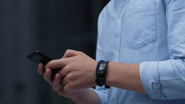 istock Businessman using smartphone texting outdoors. Male hands hold device closeup. 1468570390