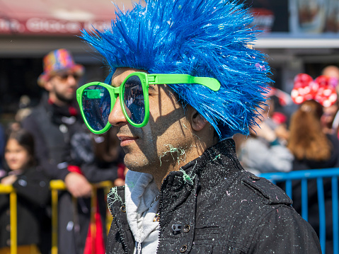 Limassol, Cyprus, February 19th, 2023:  Portrait of young man in blue wig and giant sunglasses  taking part in Children’s Carnival Parade