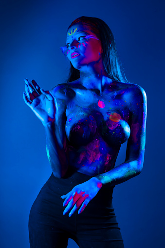 Woman modelling neon bodypaint in blue and magenta tones