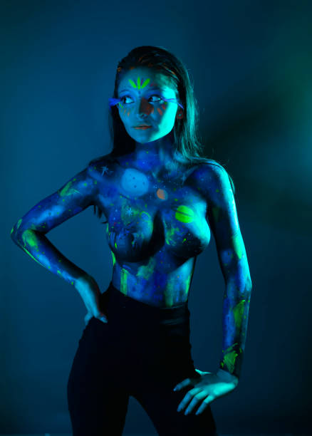 Beauty art portrait of a female painter with colorful paints on hands and face. Woman with blue eyes.