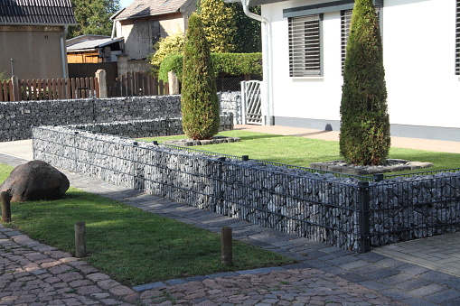 a modern front yard with gray granite stones and plants