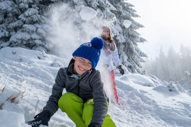 istock girl throws snow at boy 1468577970