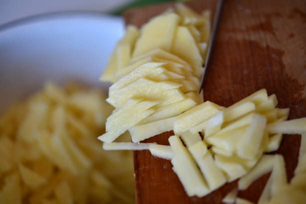 istock Slicing fresh potatoes on a cutting board. 1468578415