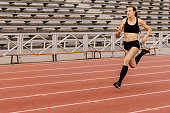 female runner running on stadium track