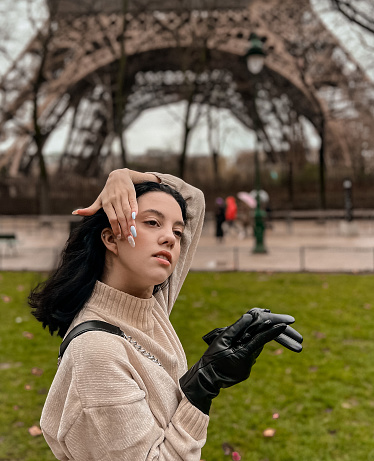 Lady near Eiffe Tower in Paris, France was made in winter. No snow, only some rain on the street.