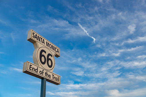 A picture of the Route 66 Santa Monica sign against a blue sky.