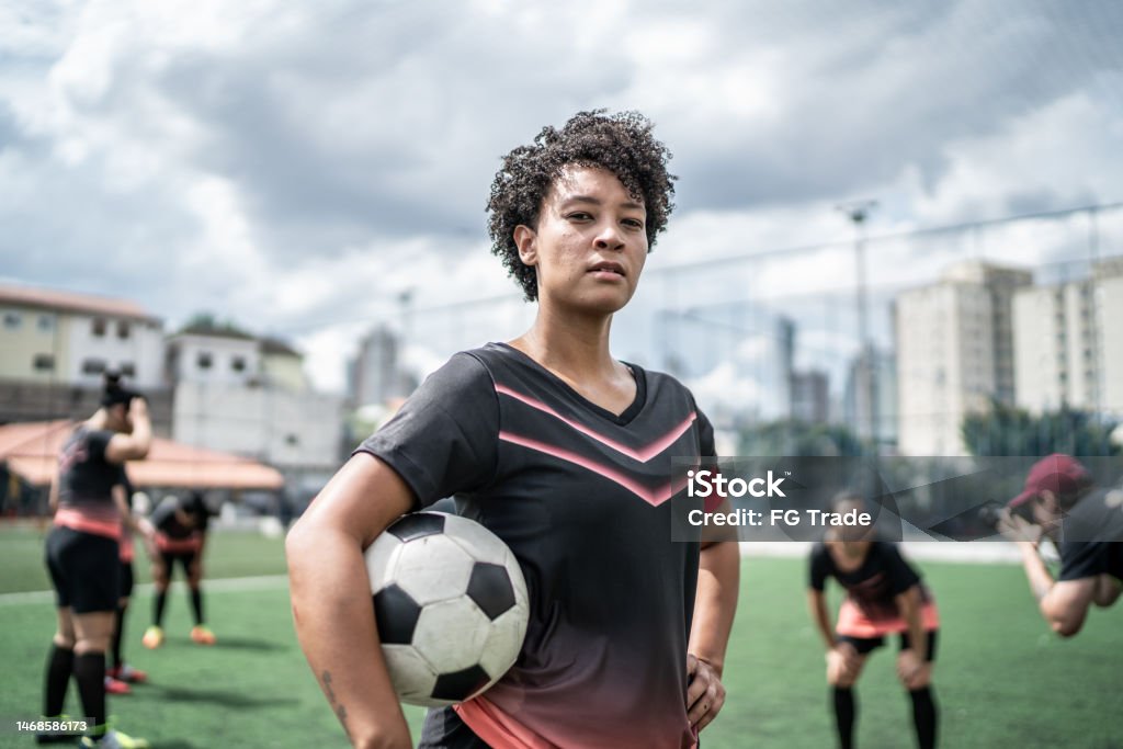 Portrait of a female soccer player holding a soccer ball in the field Soccer Stock Photo