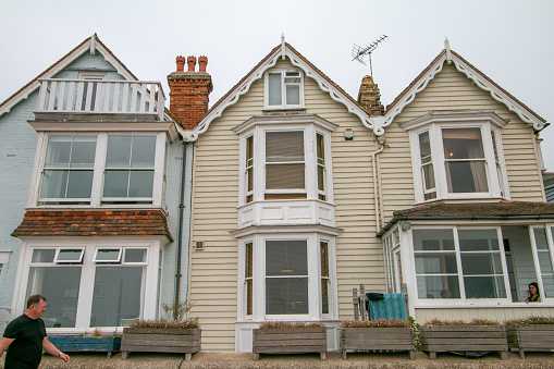 A person walking in front of two-story houses at Whitstable in Kent, England
