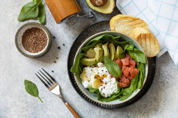 istock Classic breakfast, brunch - with poached egg, avocado, arugula, flax seeds and salted salmon on a gray background. View from above. 1468591447