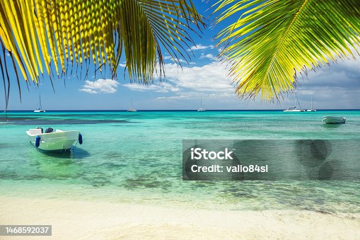 istock Beautiful caribbean sea and boat on the shore of exotic tropical island, panoramic view from the beach 1468592037