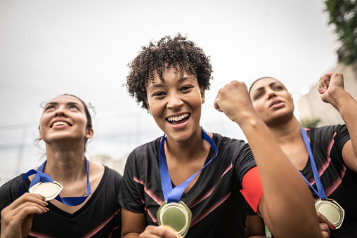 Portrait of a female soccer team celebrating with medals