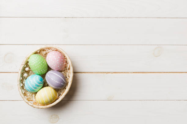 istock Multi colors Easter eggs in the woven basket on colored background . Pastel color Easter eggs. holiday concept with copy space 1468594188
