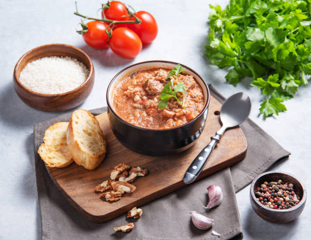 istock Thick beef or lamb kharcho soup with rice, tomato, walnuts and spices in a bowl on a light background with fresh tomatoes, herbs and bread. 1468595960