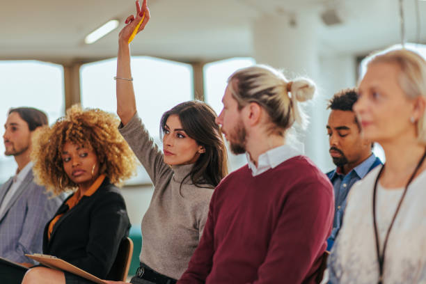 Woman raising hand in meeting.