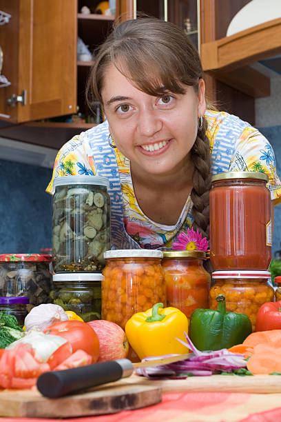 Girl with vegetables and jars Girl with vegetables and jars in the kitchen pattyson stock pictures, royalty-free photos & images