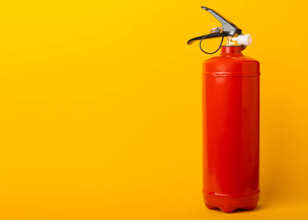 istock Fire extinguisher on a yellow background.Red fire extinguisher indoors on the wall. Fire protection, home fire extinguisher. Mockup, space for text, copy space. 1468599068