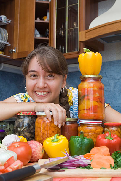 Girl with vegetables and jars Girl with vegetables and jars in the kitchen pattyson stock pictures, royalty-free photos & images