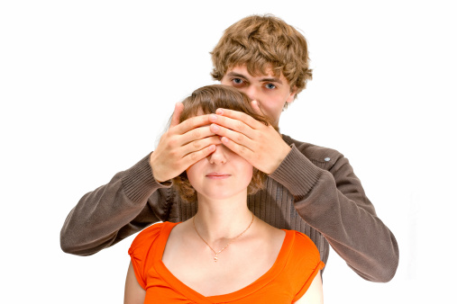 Young man covering girls eyes