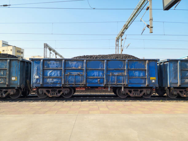 Stock photo of blue color painted open goods wagon loaded with charcoal transported to power, metal, Chemical production.Picture captured under bright sunlight at Hyderabad, Telangana, India. stock photo