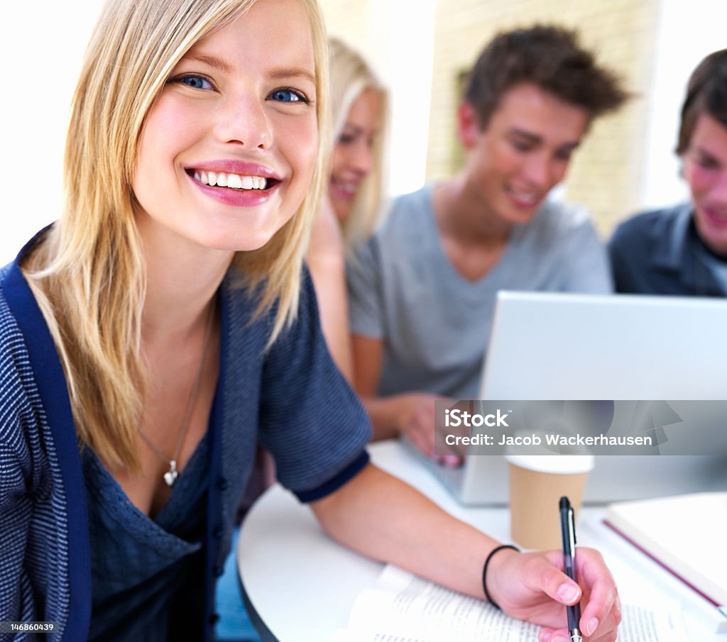 Nahaufnahme von Teenager-Mädchen lächelnd mit Freunden im Hintergrund - Lizenzfrei Internet Stock-Foto