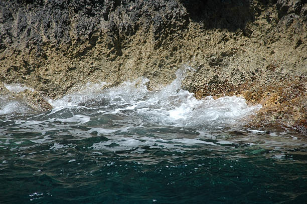 Wave hitting cliffs stock photo