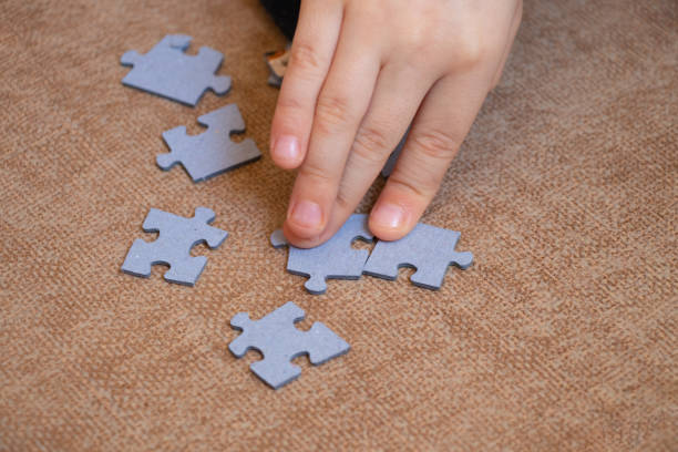 istock children's hand collects puzzles on the floor on a brown tile 1468611283